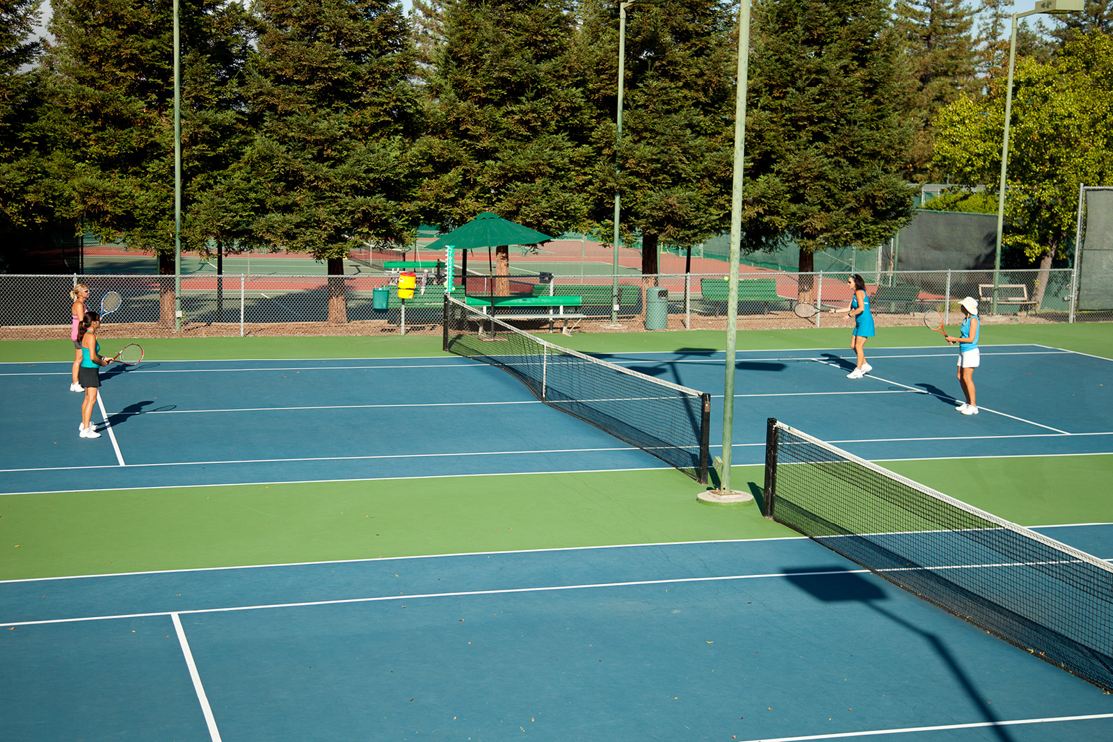 People playing tennis on the outdoor tennis courts